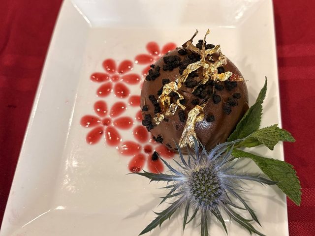 Chocolate dome with gold leaf and raspberry coulis