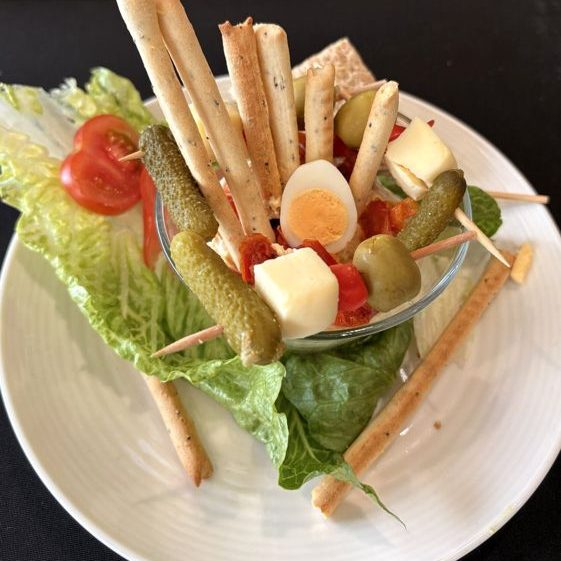 Crudité glass with quail egg and grissini on a lettuce leaf